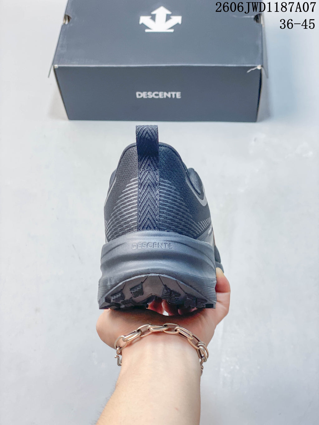 Rear view of a dark gray DESCENTE sneaker with a heel pull tab.