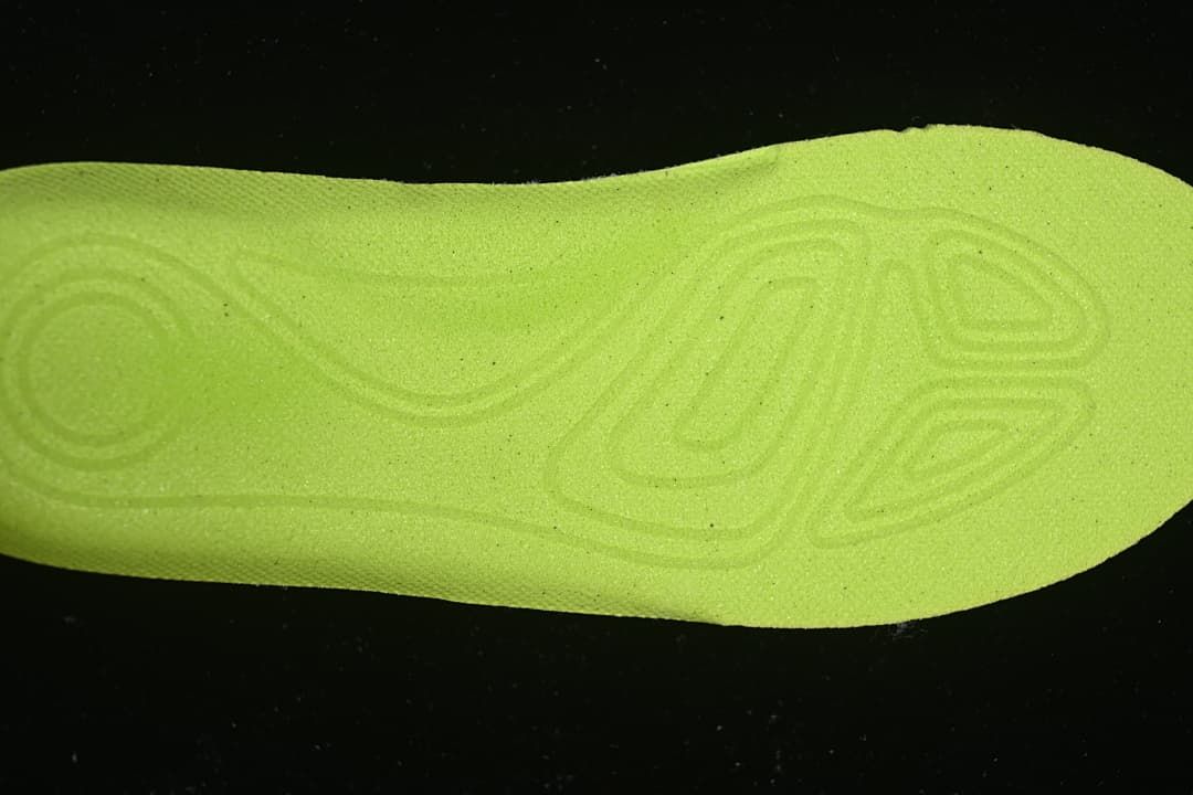 Bright lime-colored shoe insert shown separately