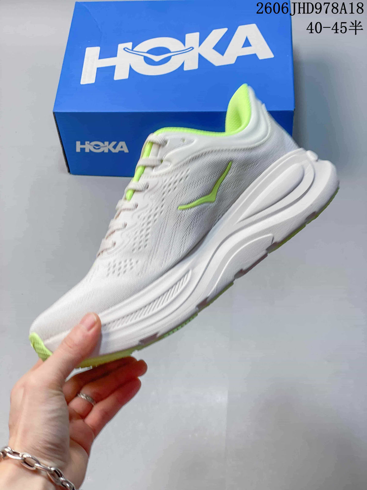 Side profile of a white Bondi 9 running shoe with neon-green details and a sculpted midsole