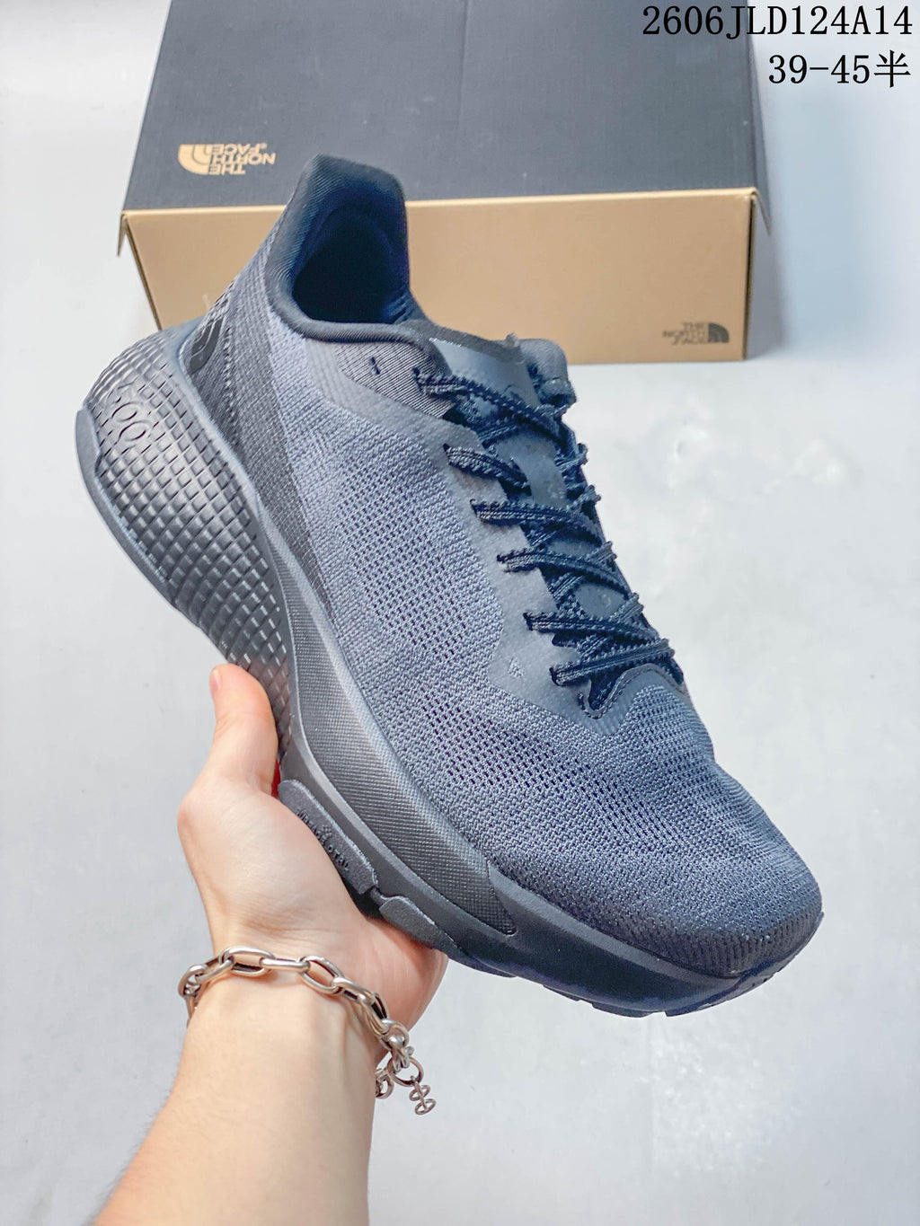 Side view of a gray trail-running shoe showing its textured outsole
