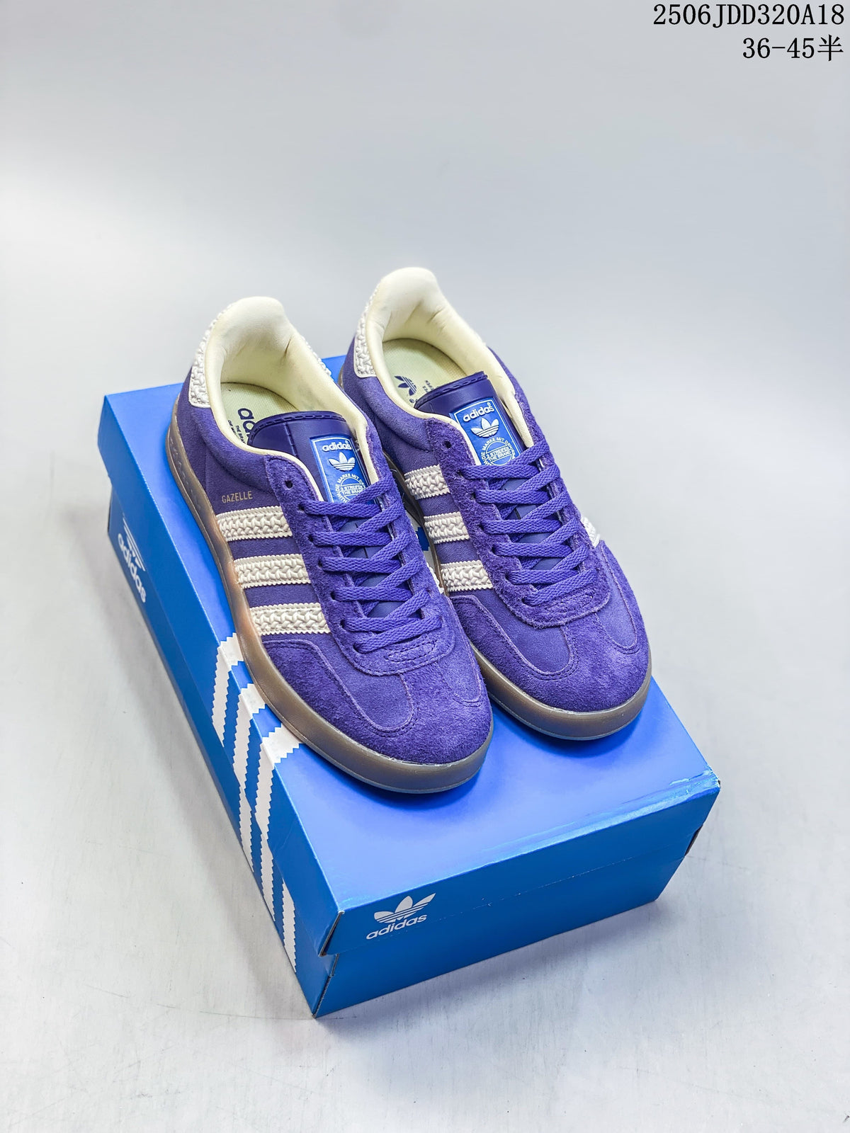 Purple Adidas Gazelle 90 low-top sneakers with cream stripes and gum outsole on a blue shoe box.