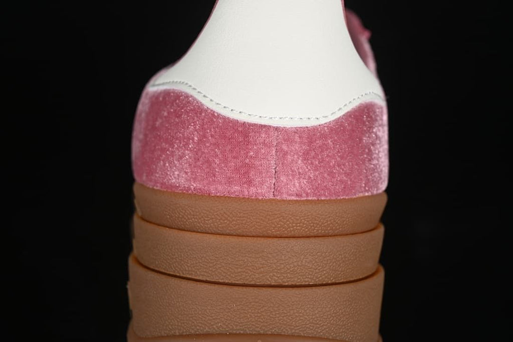 Rear view showing the white heel tab, pink upper, and layered gum sole