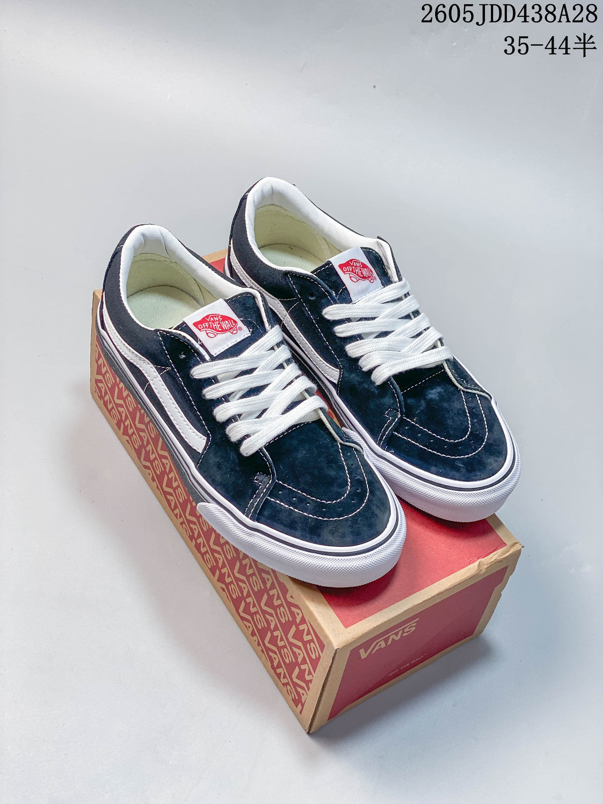 Pair of dark green Vans Old Skool sneakers with white laces and side stripes, shown on a Vans box.