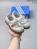 Pair of cream and pink Adidas Samba Jane kids' shoes with laces, instep straps, and brown outsoles.