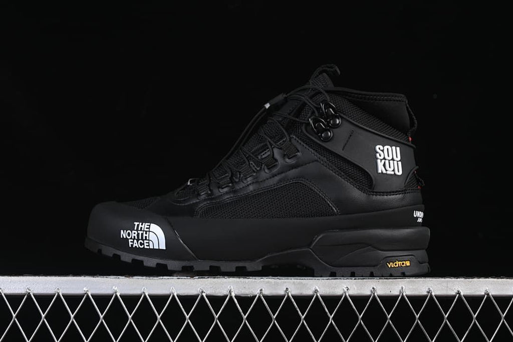 Black mid-height hiking shoe in profile with white logo details