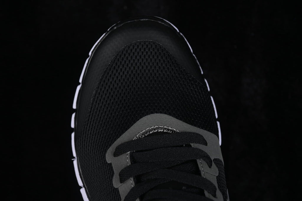 Top-down close-up of the black mesh toe box and black laces.