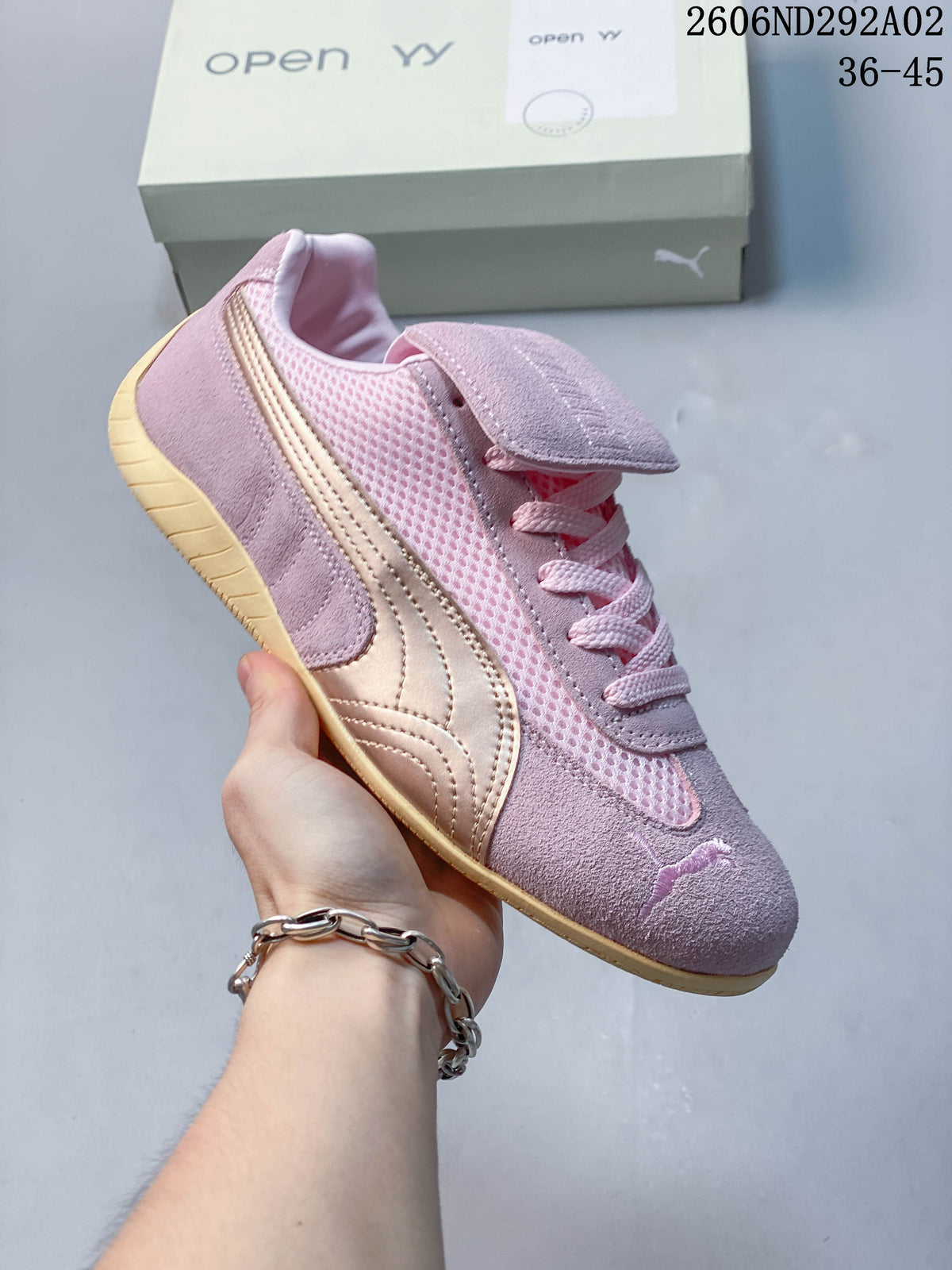 Angled side view of the pink sneaker with its metallic-look stripe, mesh panels and low-profile outsole.