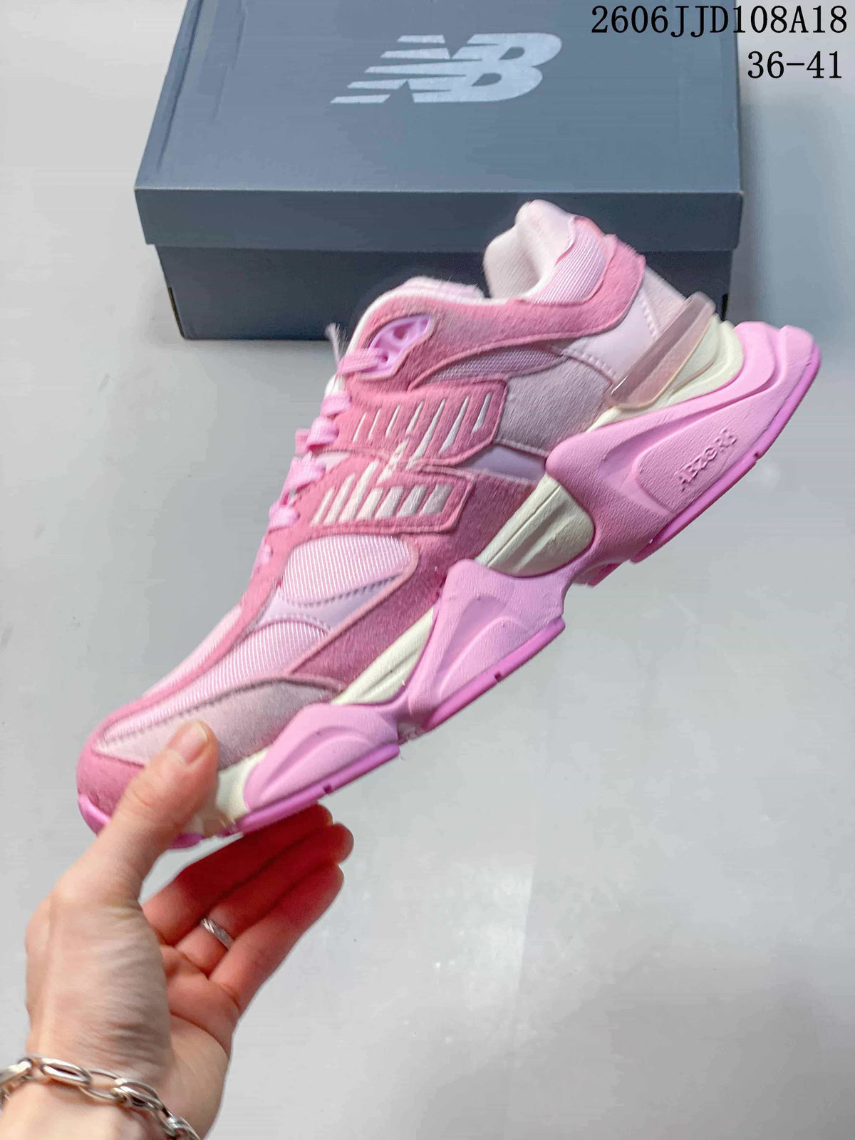 Side view of a pink New Balance sneaker with layered panels