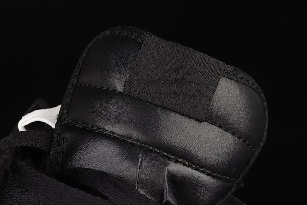 Close-up of the tongue and woven label on the black sneaker.