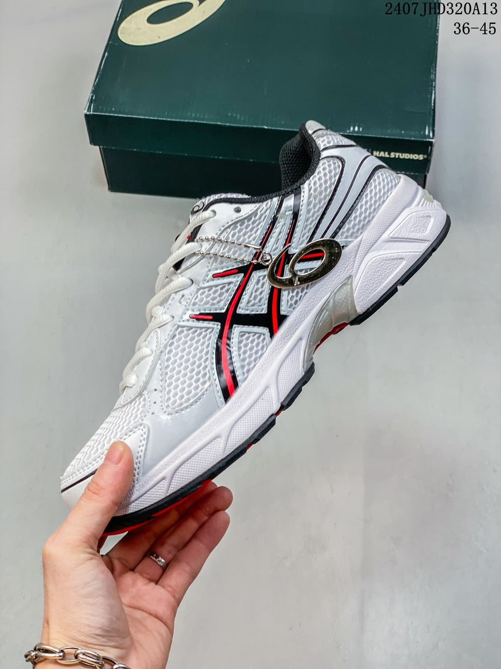 Side view of the white mesh-look sneaker with black and red overlays