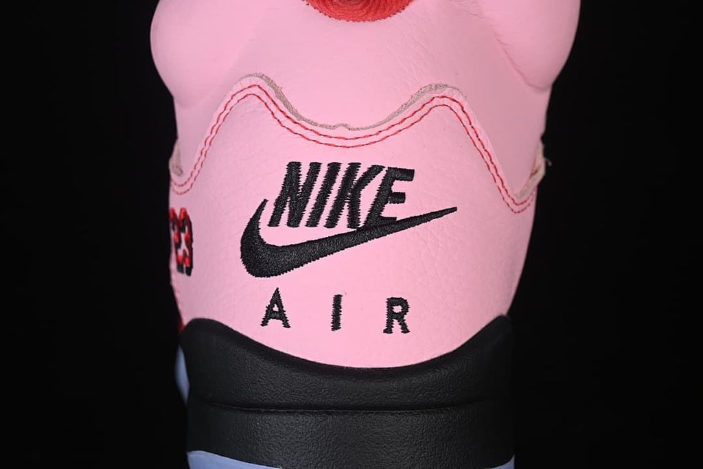 Rear view of the pink sneaker showing Nike Air branding and the black heel section.