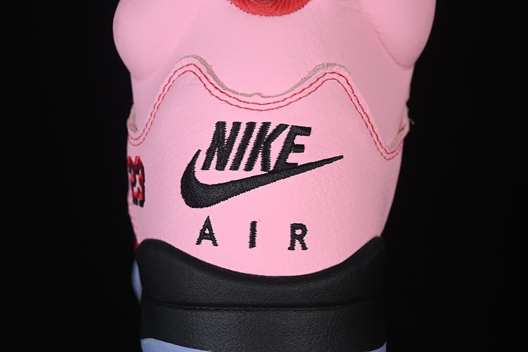 Rear view of the pink sneaker showing Nike Air branding and the black heel section.