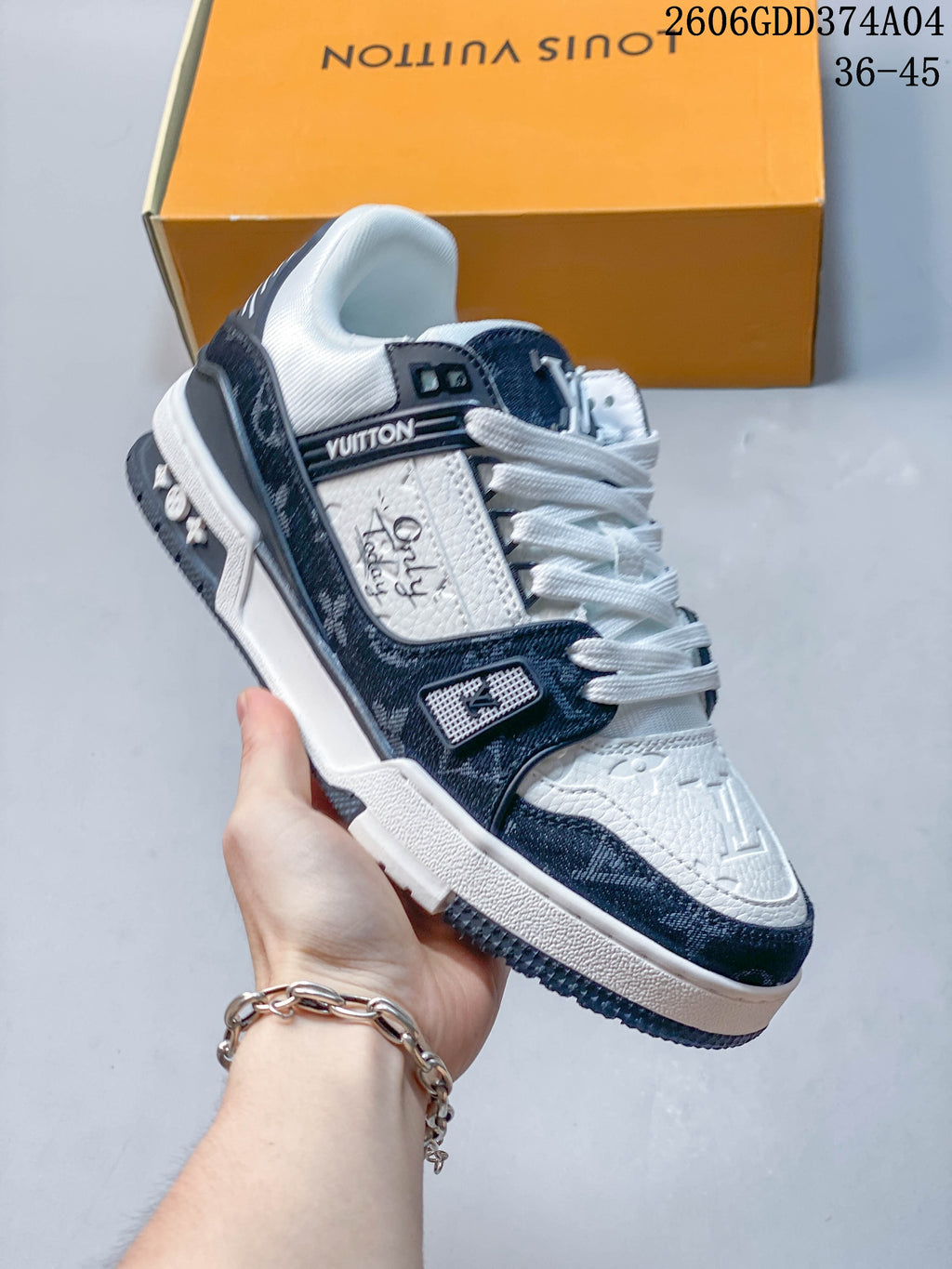 Angled side view of a white and navy Louis Vuitton Trainer sneaker.