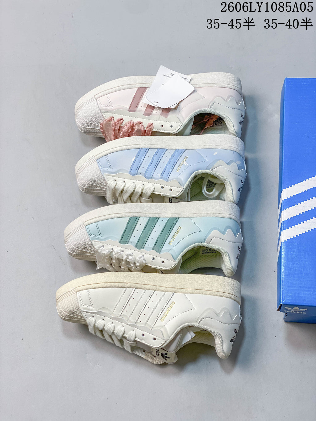 Four cream Superstar color variations, including pink, blue, green, and tonal accents
