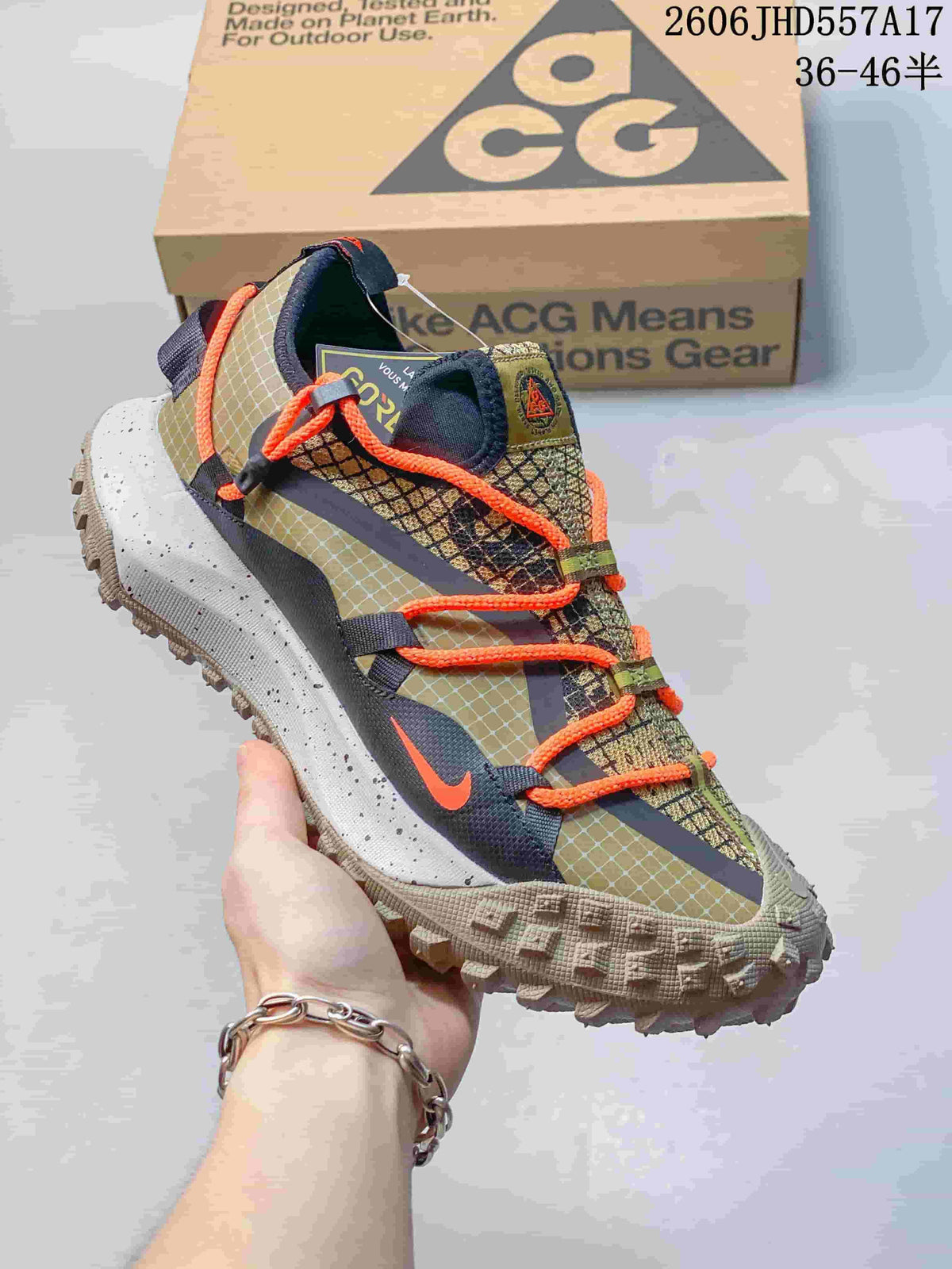 Nike ACG Mountain Fly sneaker in olive, tan, and orange with cord laces and a rugged lugged outsole.