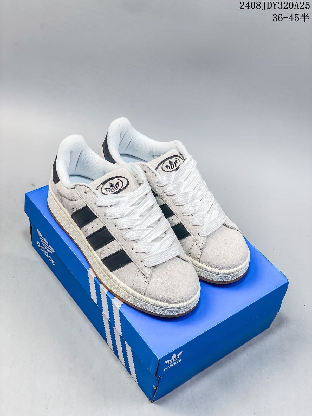Pair of light grey and black adidas Campus 00s sneakers on a blue shoe box