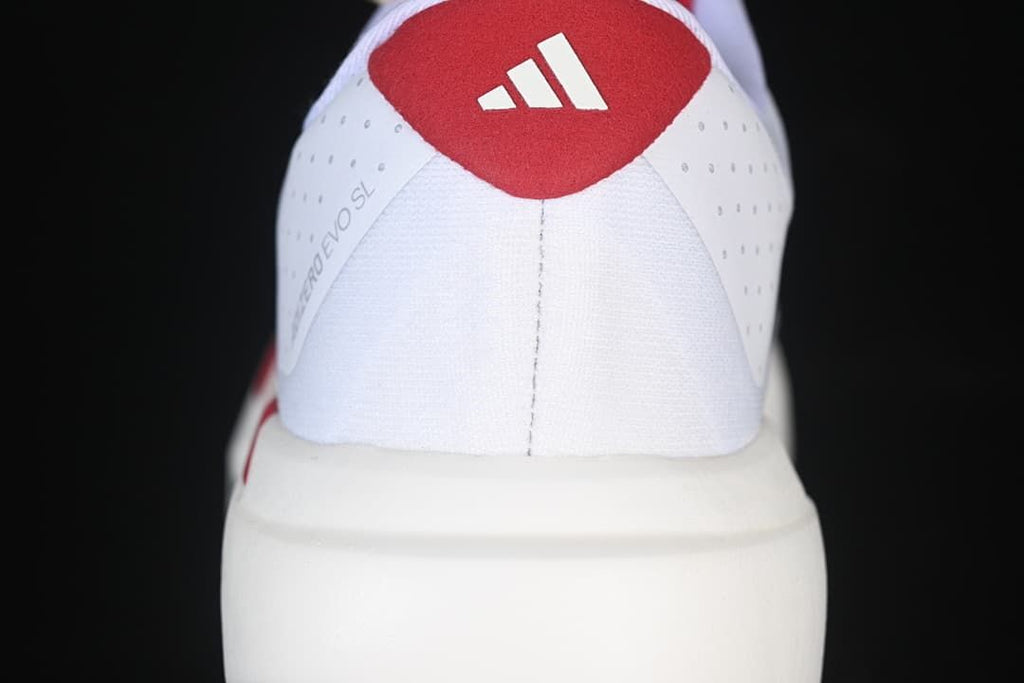 Rear view of the shoe with a red heel panel and Adidas logo