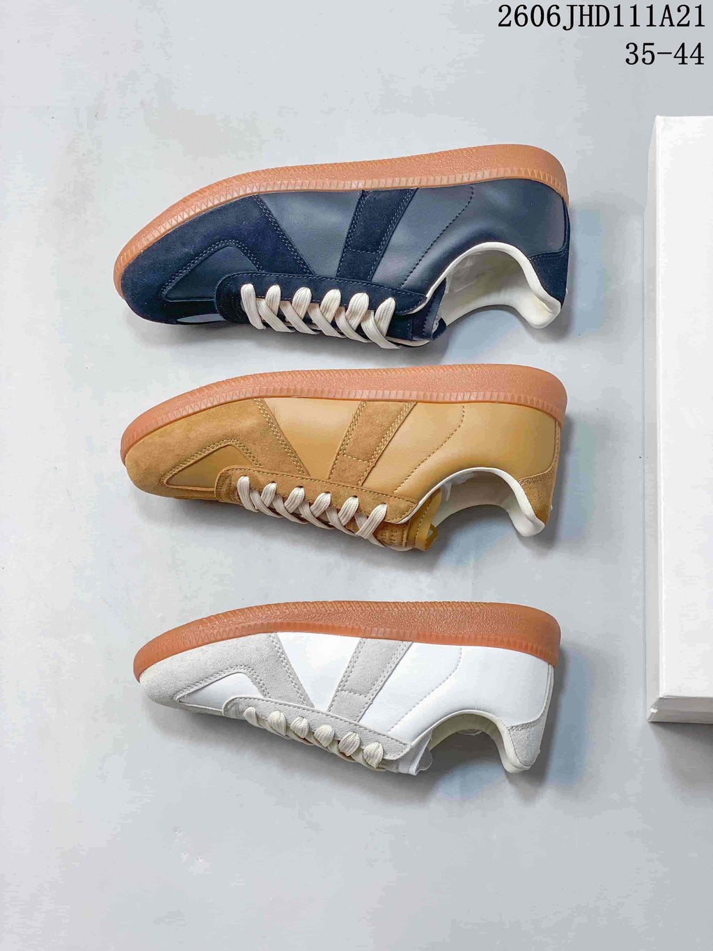 Three colorways of low-top sneakers shown from the side: navy, tan, and white-gray