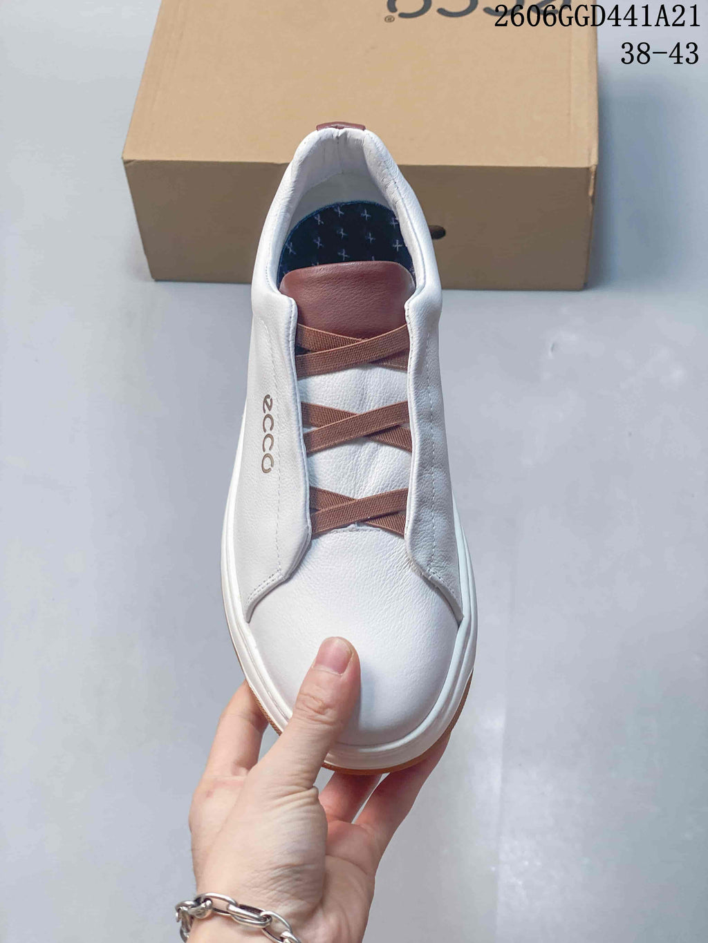 Top view of the sneaker showing elastic cross-over straps and a white upper.