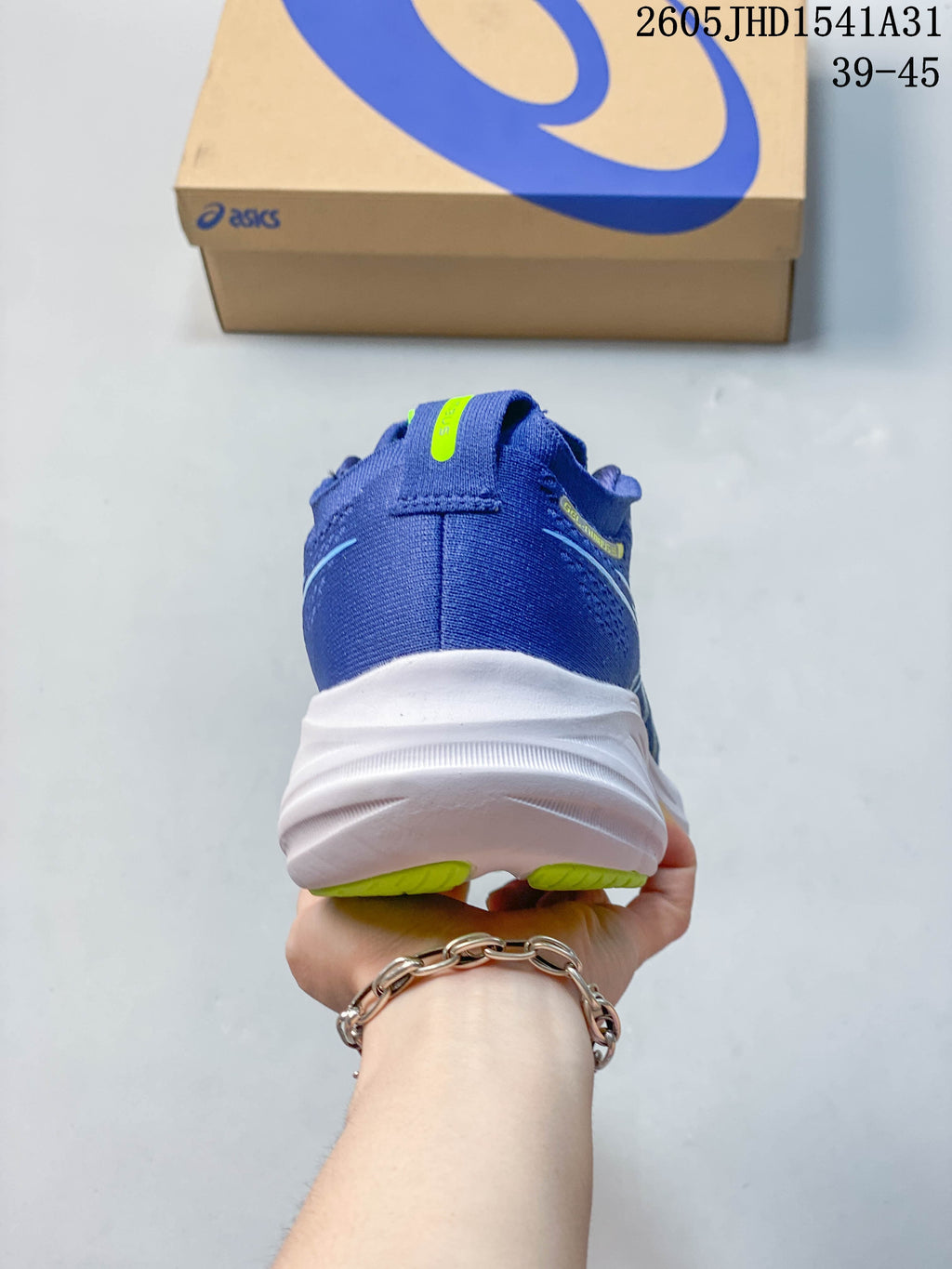 Rear view of a blue running shoe with a white midsole and lime outsole accents