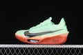 Side view of mint-green Nike ZoomX Vaporfly Next% 3 shoes with dark Swoosh accents and coral-orange soles.