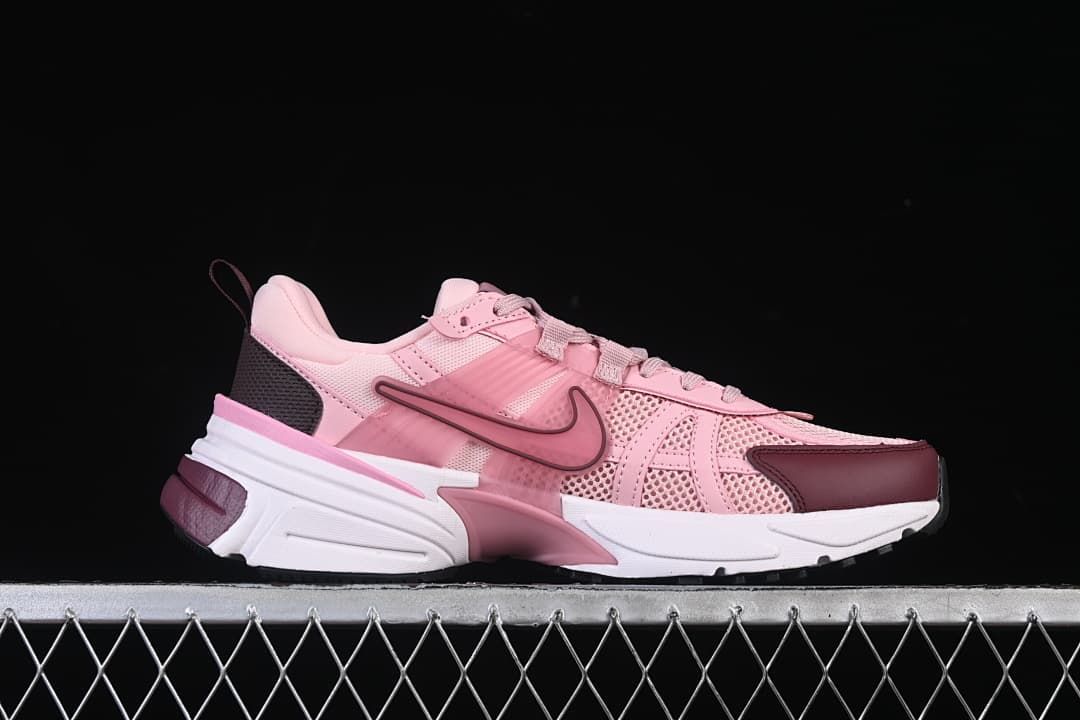 Side profile showing the pink upper, burgundy accents, and sculpted sole