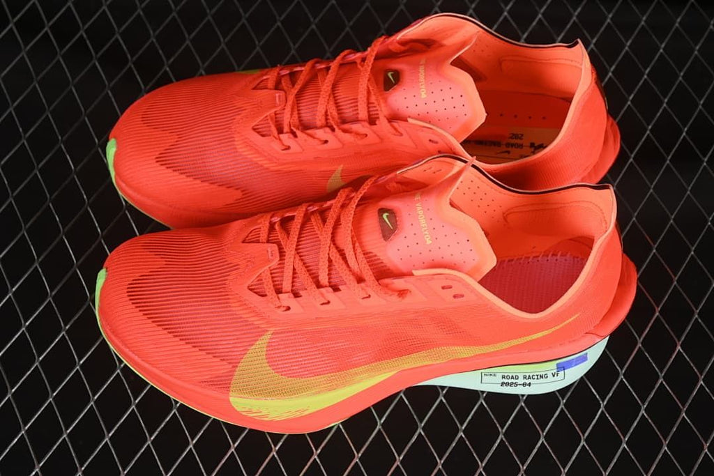 Pair of coral-orange road-running shoes shown from above and the side.