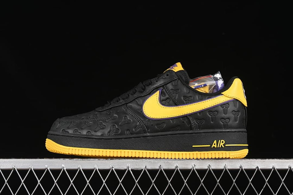Side view of a black low-top sneaker with yellow and purple accents and an embossed upper.