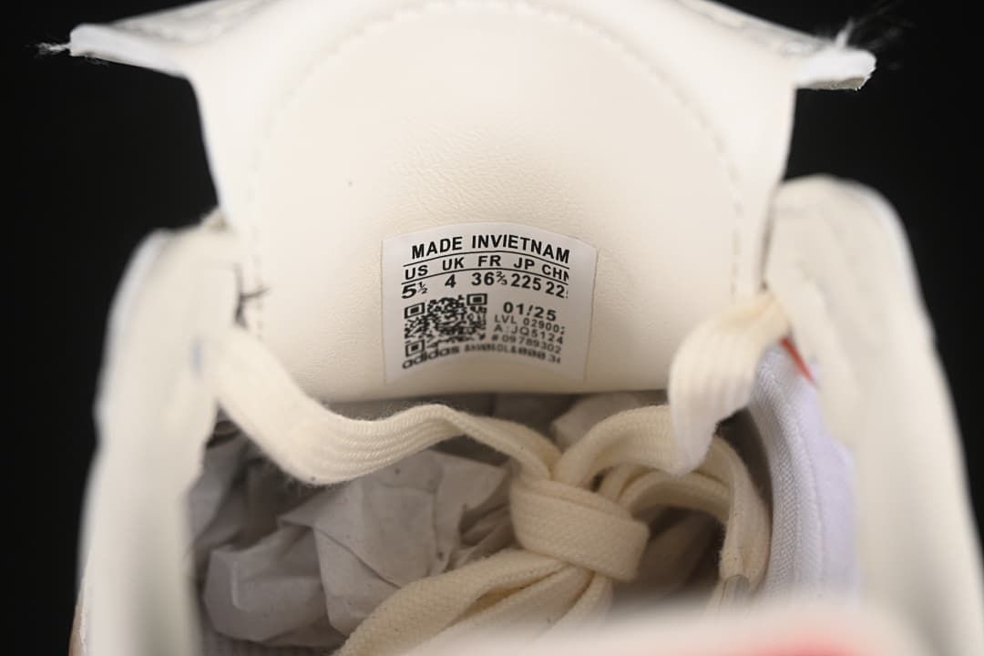 Close-up of the tongue size label and cream-colored laces.