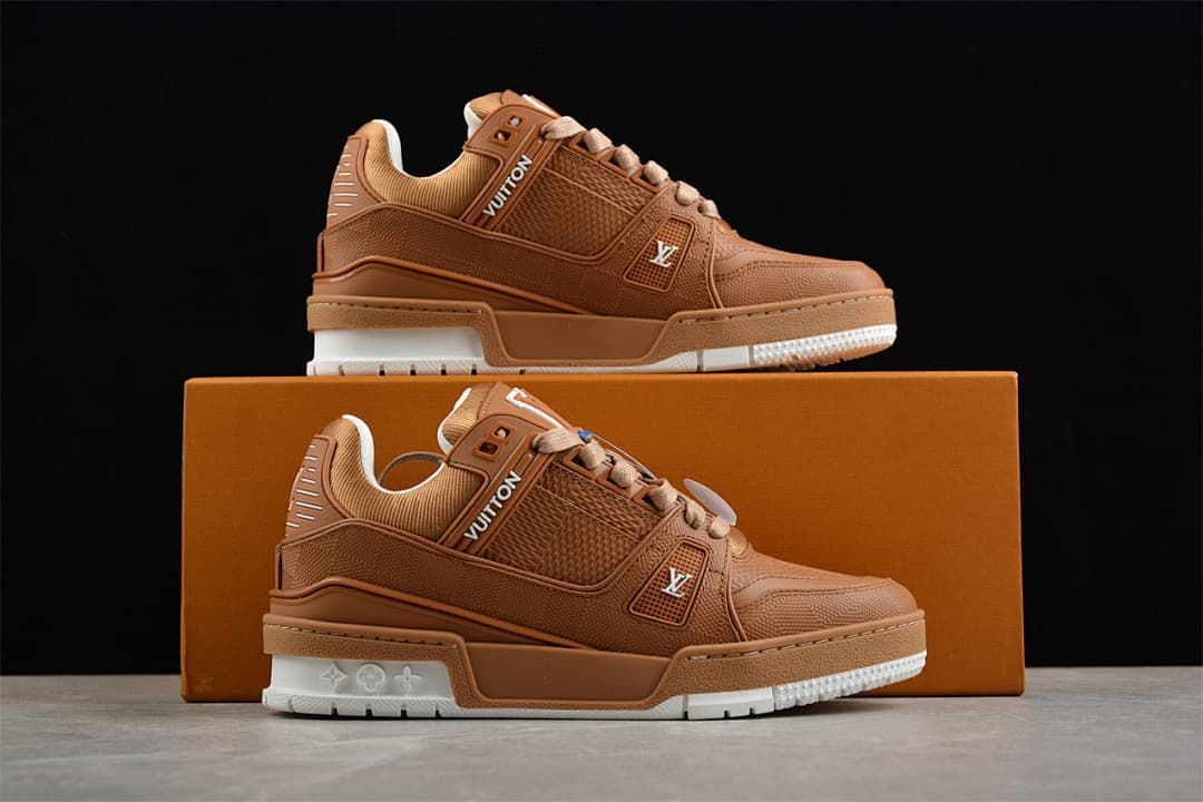 Two brown low-top sneakers displayed on an orange-brown box.