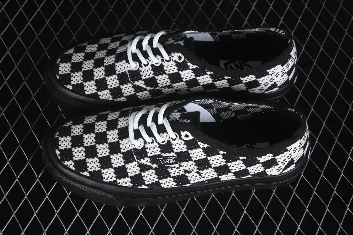 Angled side view showing the checkerboard upper, white laces, Vans side branding and black sole edge.