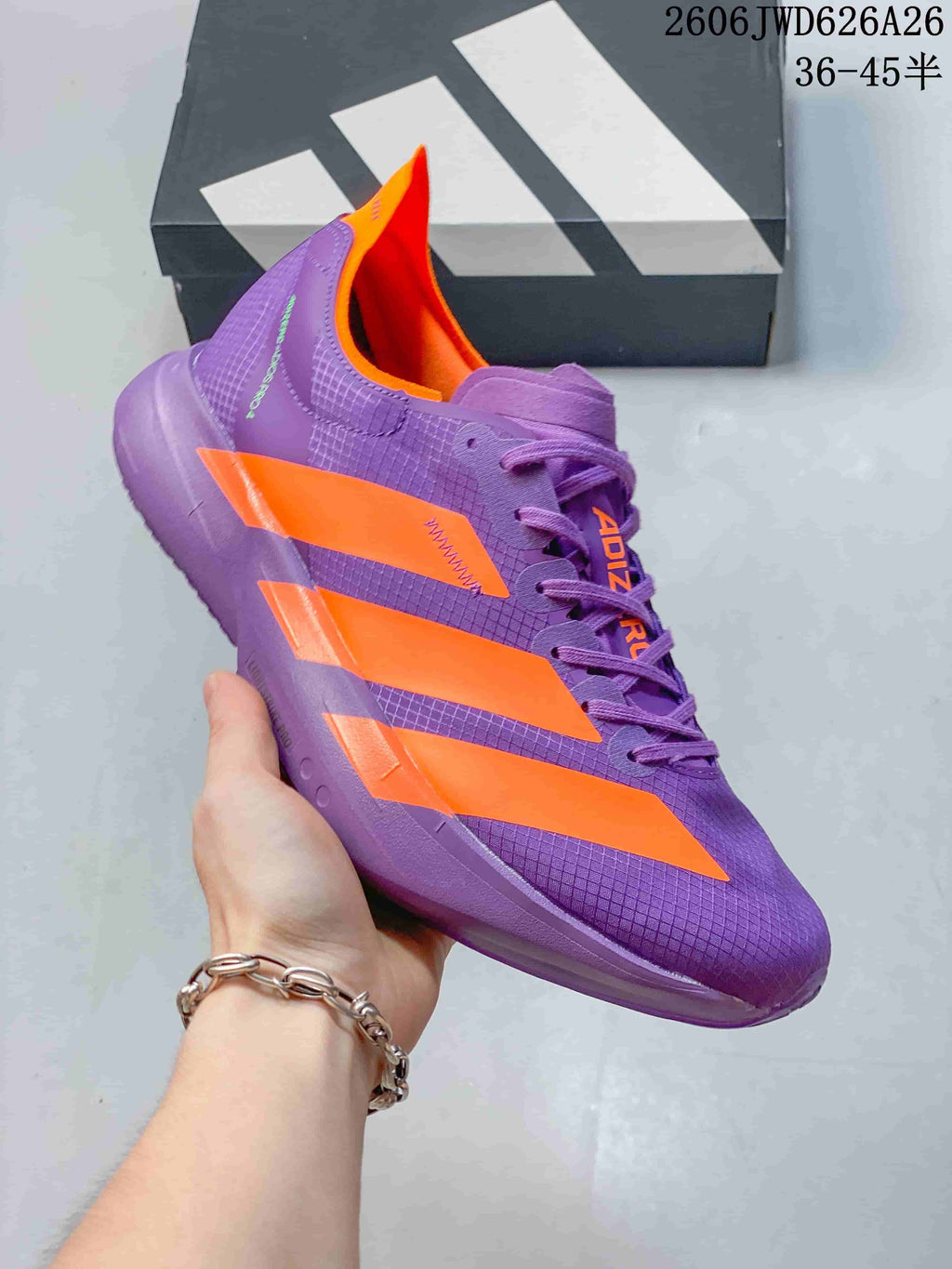Purple and orange Adidas Adizero Adios Pro 4 shoe shown from the side.