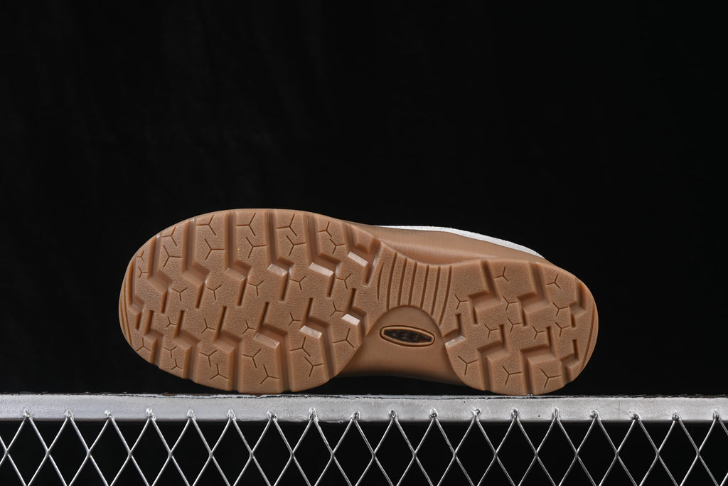 Underside view showing the gum-colored outsole and its lugged tread pattern.