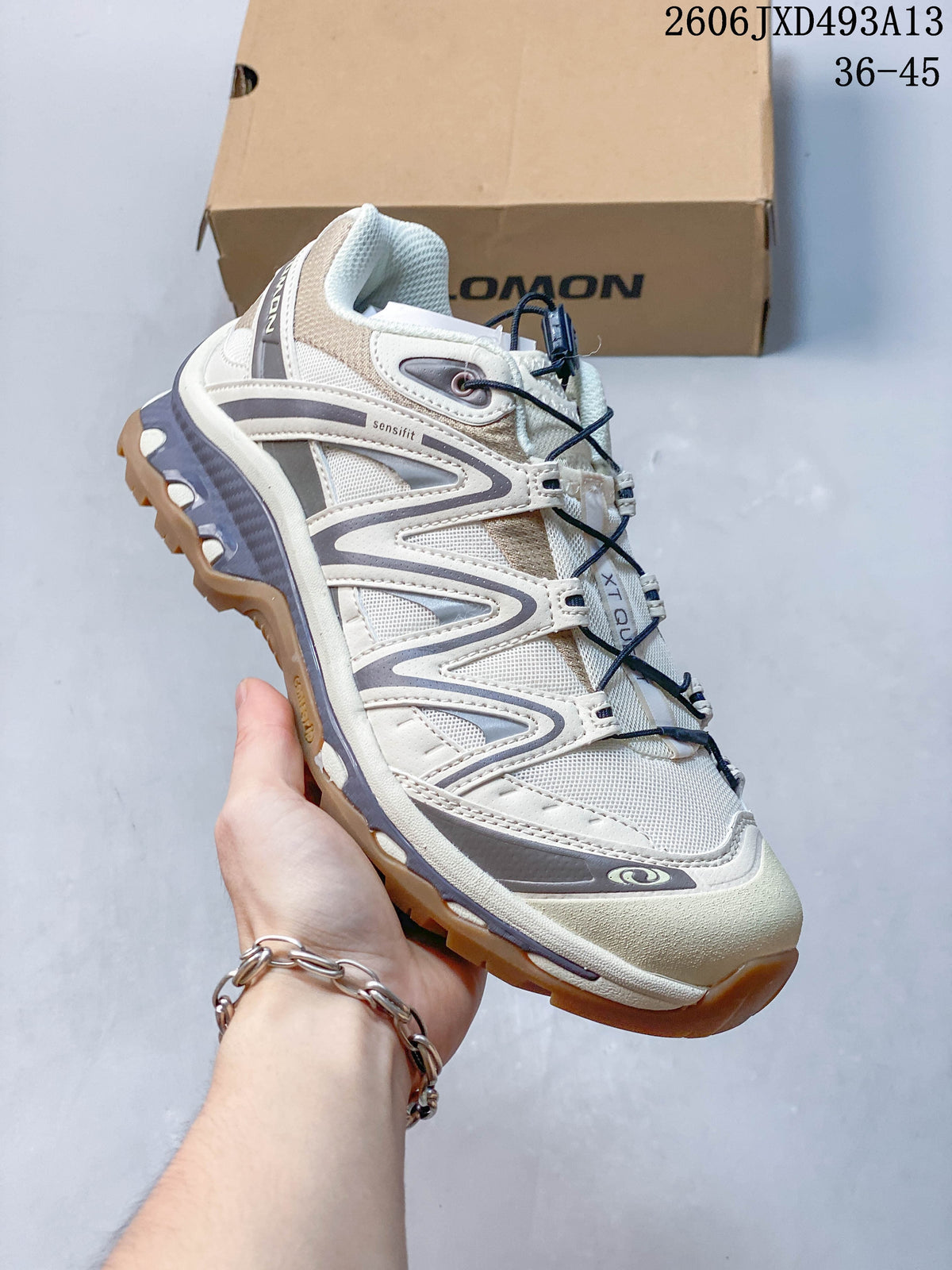 Angled side view of a cream and gray Salomon XA Pro 3D sneaker.
