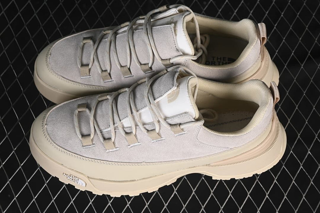 Pair of light grey and cream low-top sneakers viewed from above