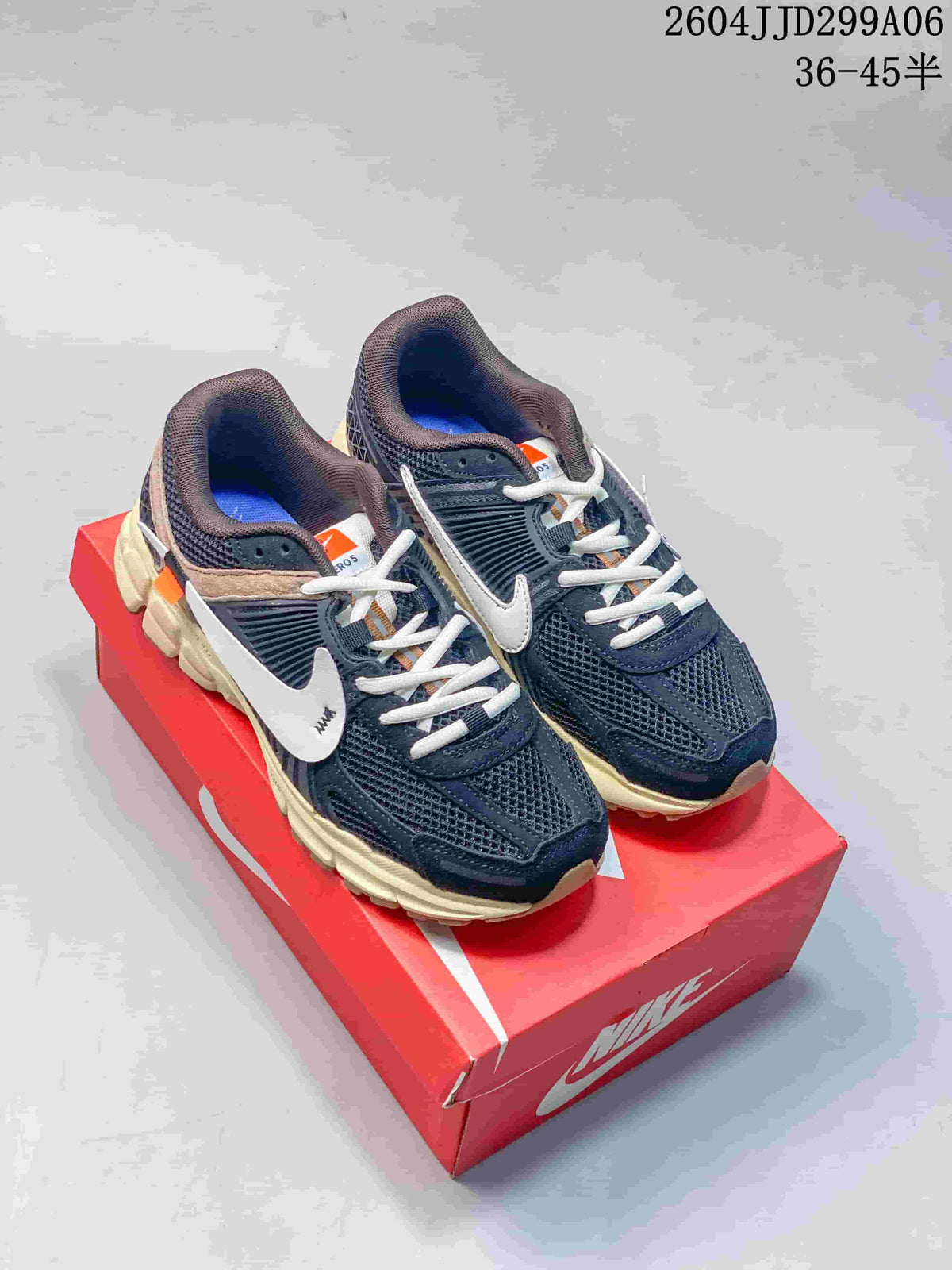 Pair of dark navy Nike Zoom Vomero 5 sneakers with light laces and contrasting details.