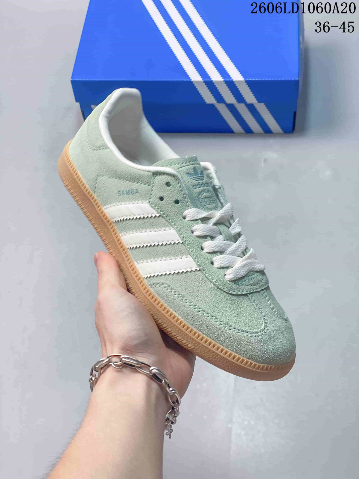 Angled side view highlighting the pale green upper, white stripes, and gum sole.