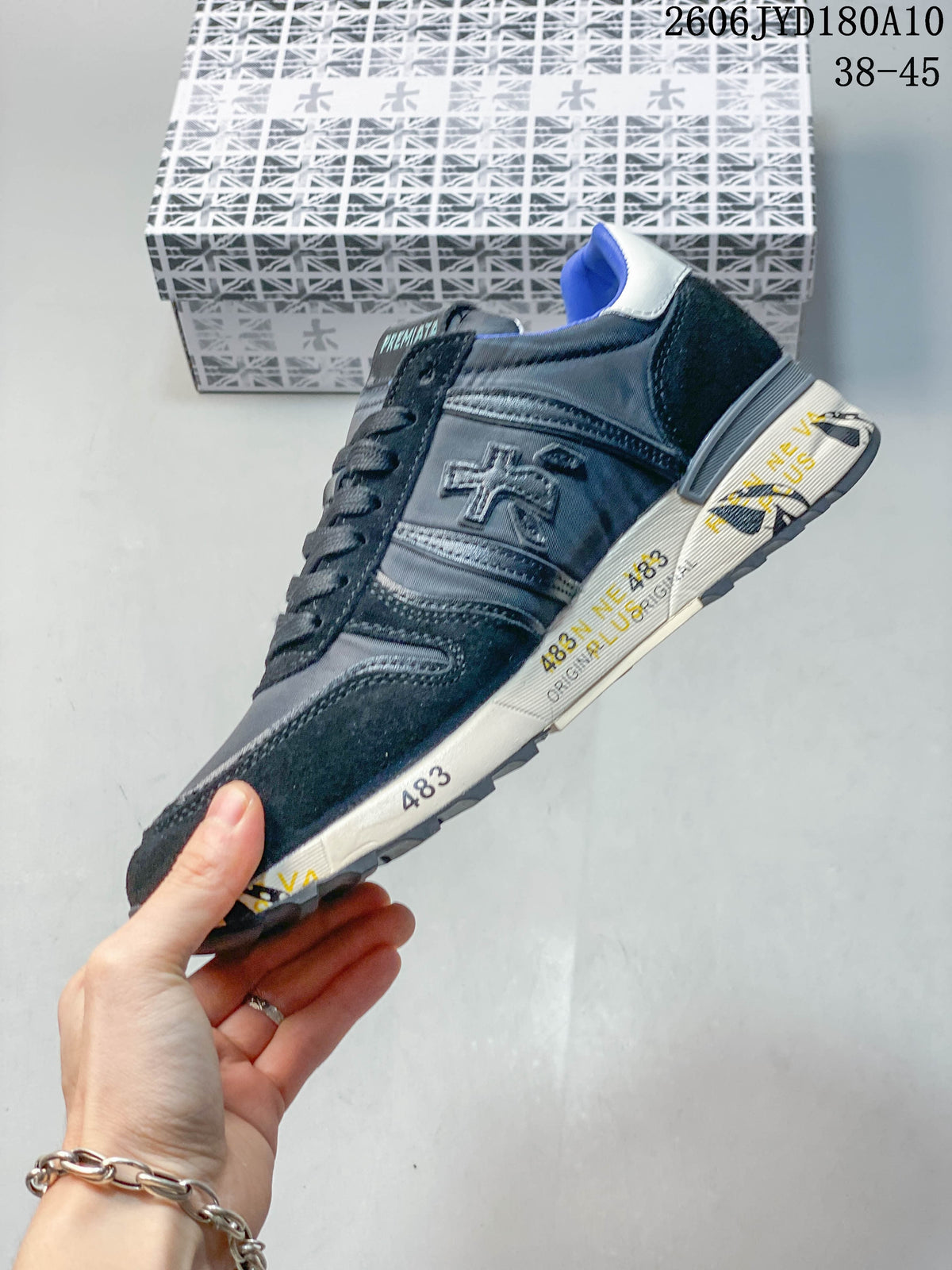 Side view of a navy and gray Premiata trainer with a patterned midsole
