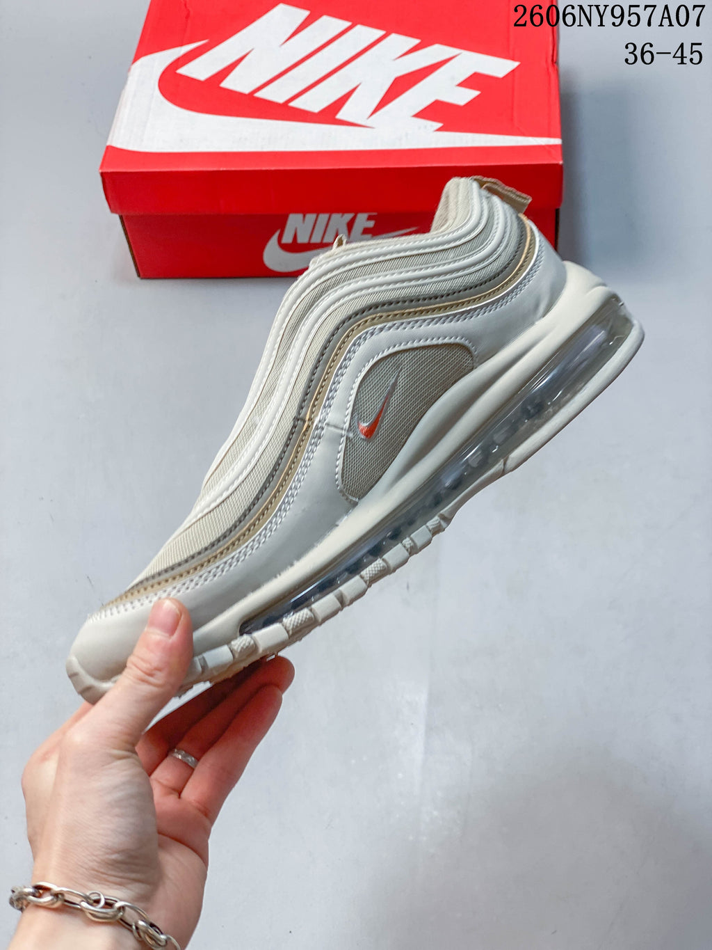 Side view of a beige Nike Air Max 97 sneaker showing layered panels and the heel air unit