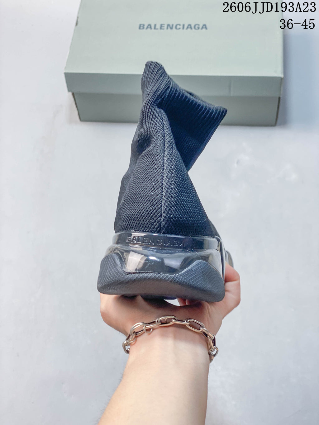 Rear view of a gray sock sneaker with a sculpted segmented sole