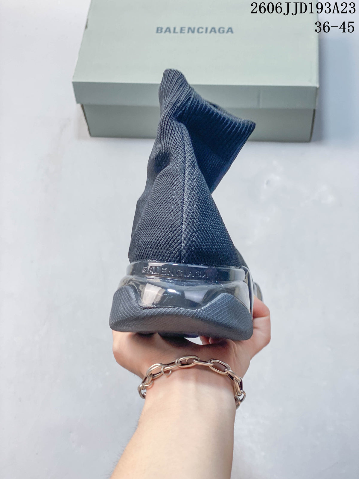 Rear view of a gray sock sneaker with a sculpted segmented sole