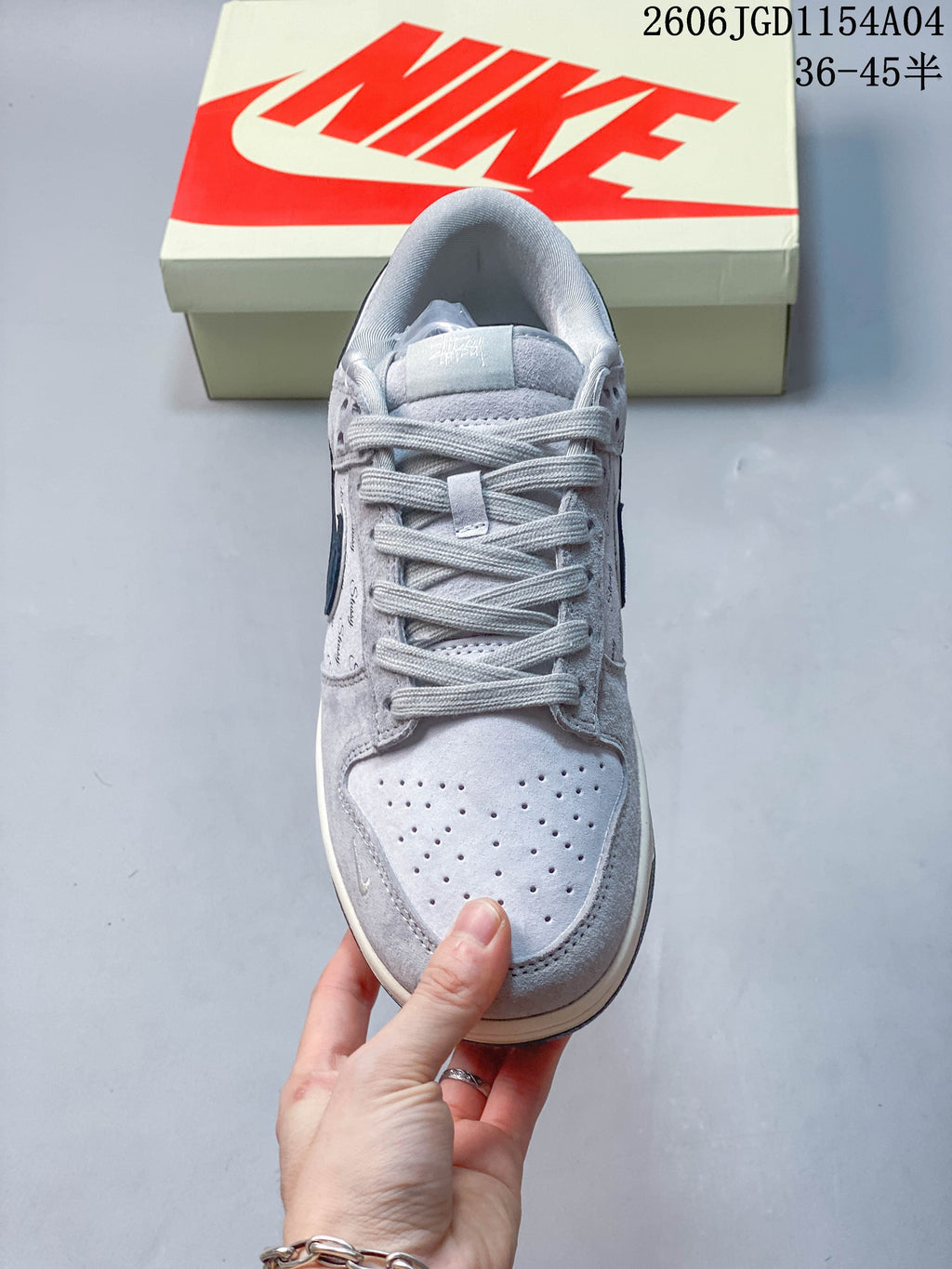 Top view of a grey low-top sneaker showing the laces and perforated toe box