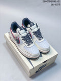 Pair of white low-top sneakers with navy and red accents, shown on a shoe box.