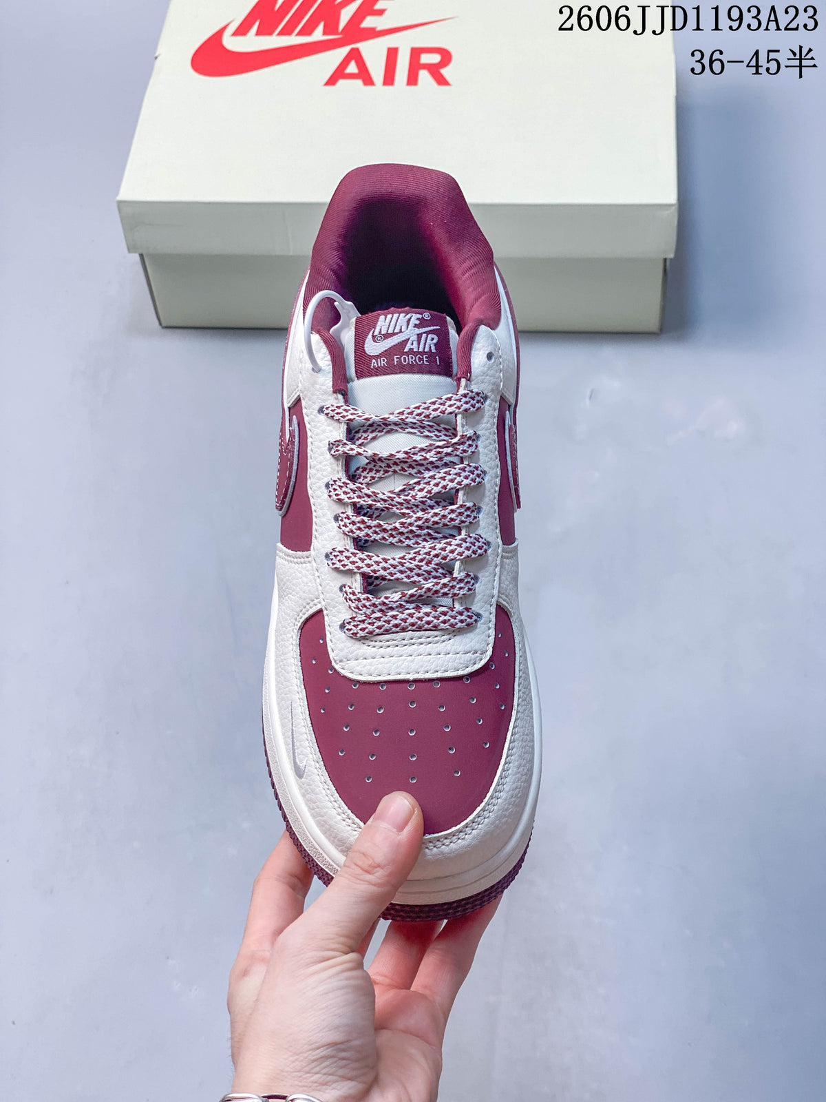 Top view showing patterned laces, a perforated burgundy toe panel, and tongue branding.