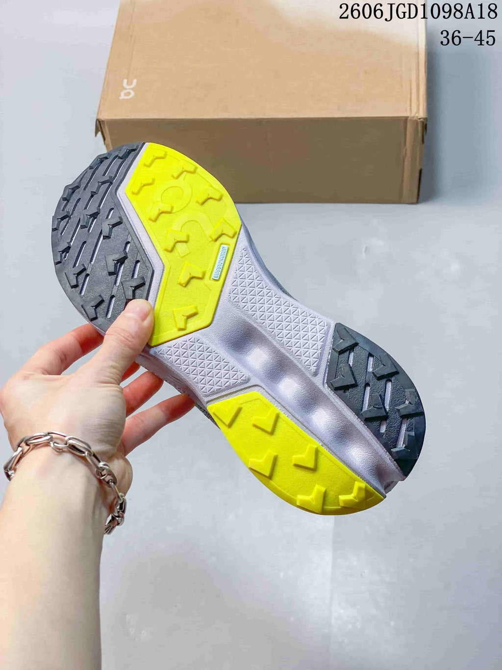 Close-up of the shoe outsole with dark gray and bright yellow tread sections