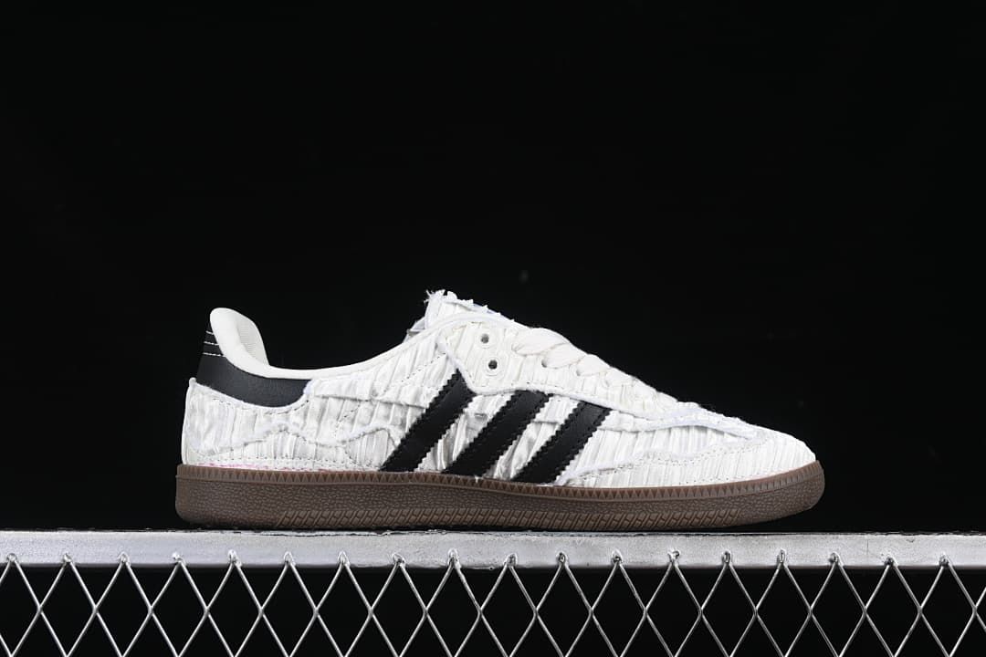 Side profile of a white sneaker with black stripes and a dark brown sole