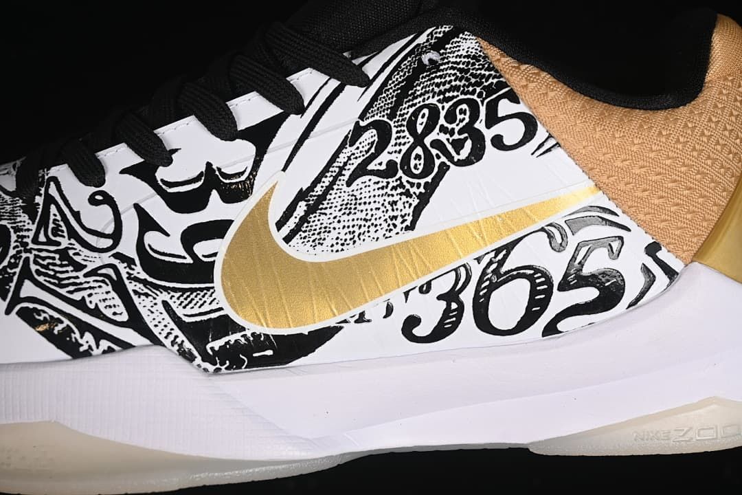 Close-up of black-and-white graphic lettering and a gold Swoosh on the shoe upper