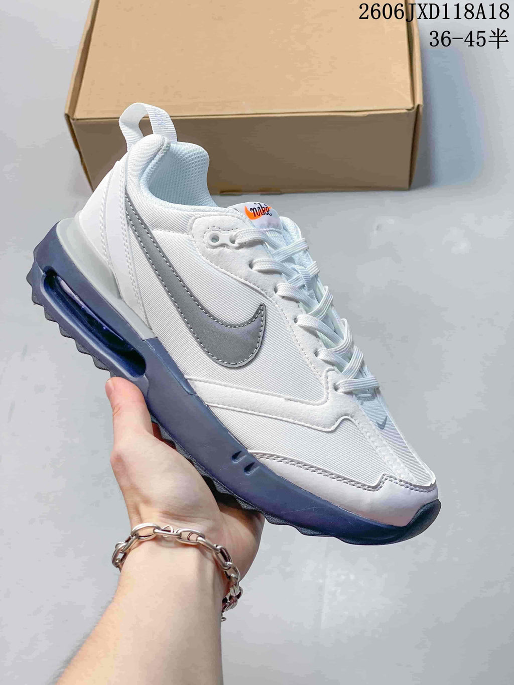 White Nike Air Max Dawn sneaker with gray accents and a dark blue-toned sole