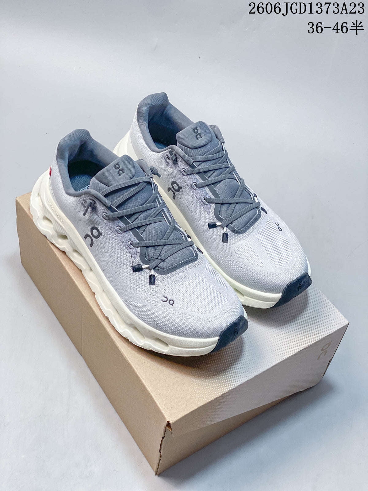 Pair of gray and white On Cloudtilt Remix sneakers on a shoe box