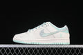 Side view of an off-white and mint-green Nike SB Dunk Low sneaker with patterned Swoosh and heel accents.